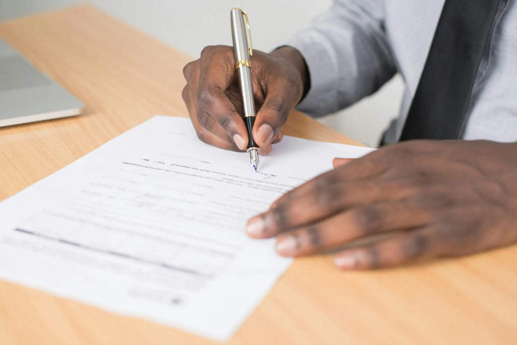 uomo che firma documento DISBRIGO PRATICHE